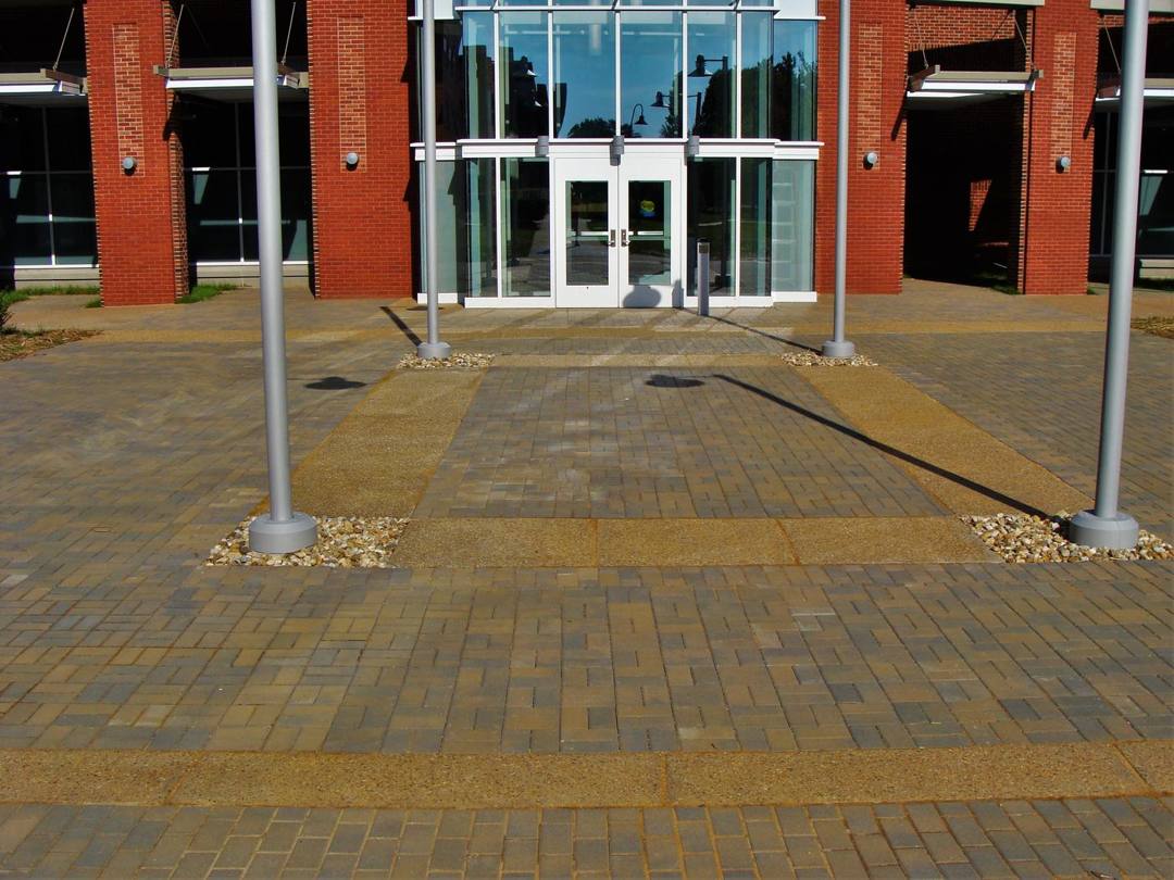 Paver entrance plaza outside a brick campus building