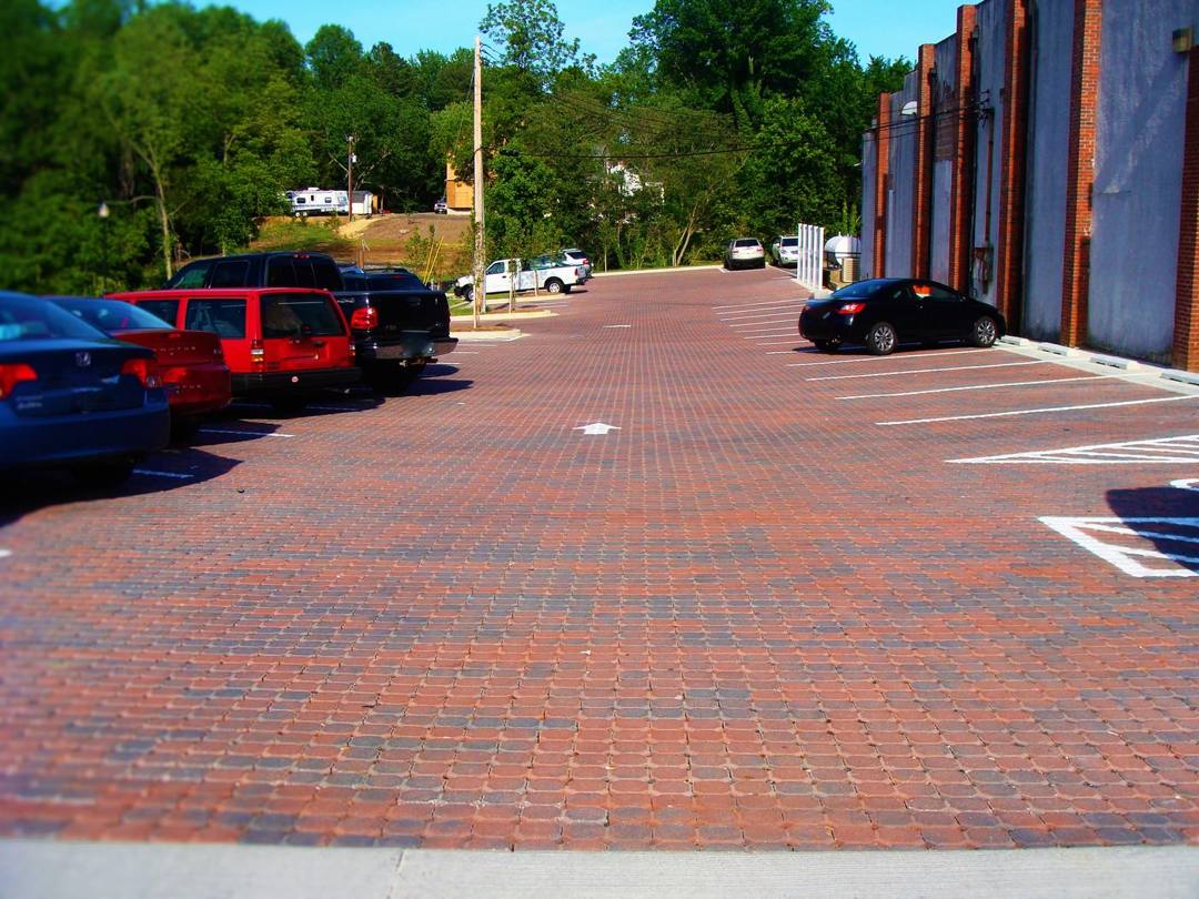 Red clay paver parking lot beside a commercial building