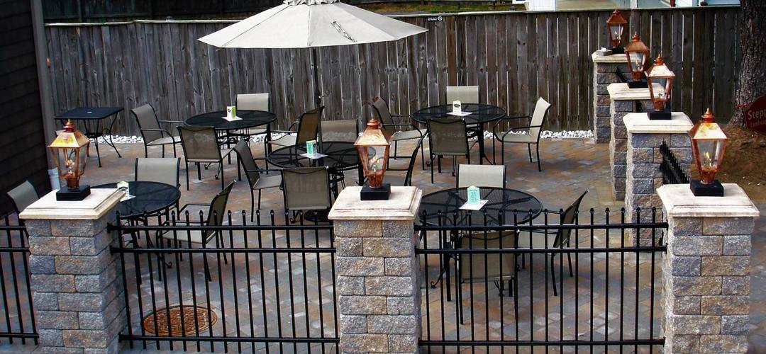 Old Towne Pub patio with umbrella tables and pillar lanterns
