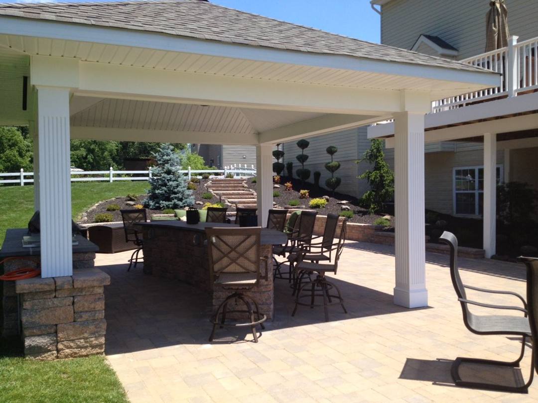 Covered outdoor bar with stools on a paver patio