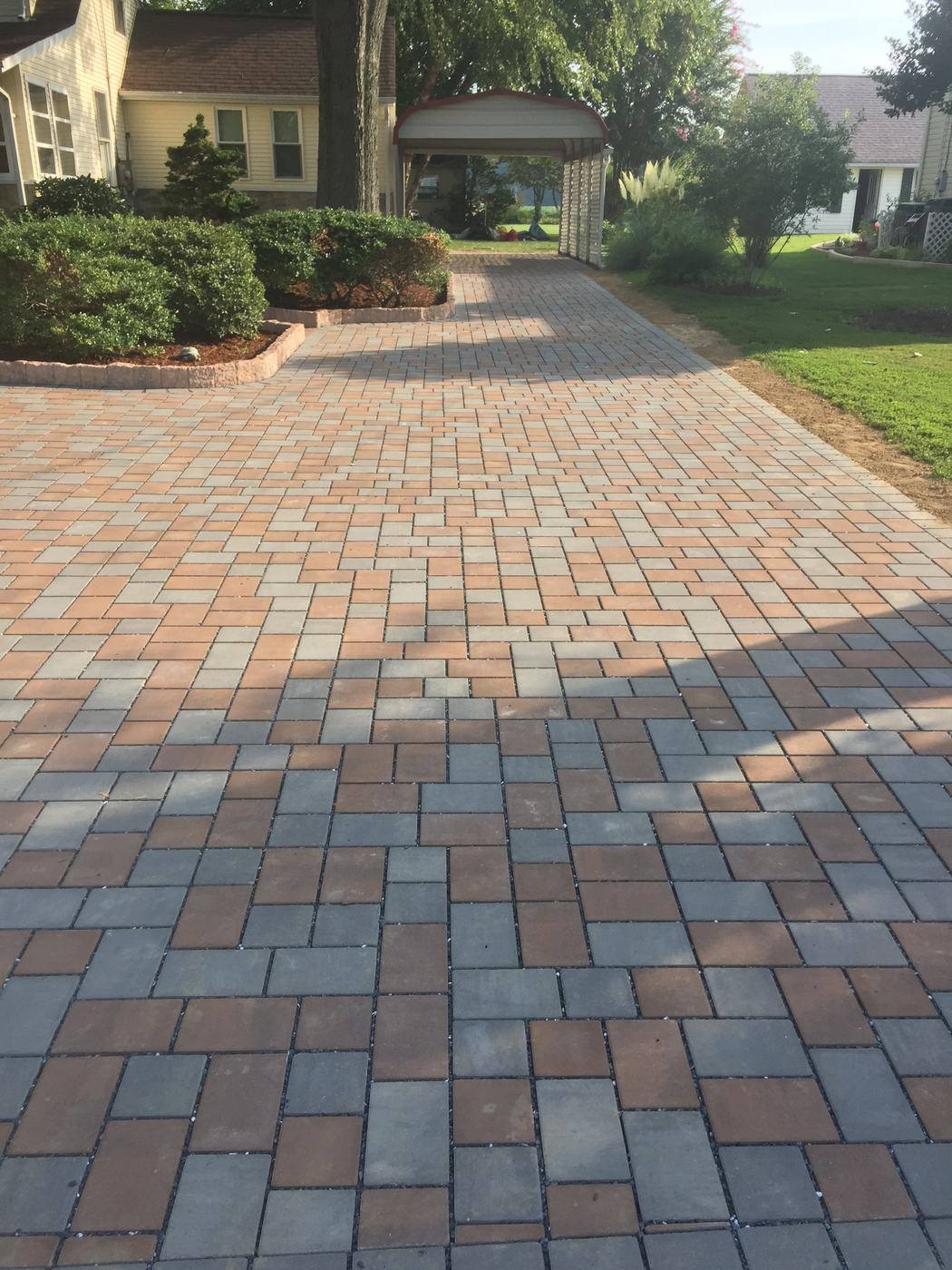 Multicolor paver driveway leading to a garage