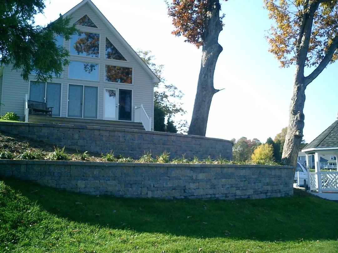 Two-tier block retaining walls below a home
