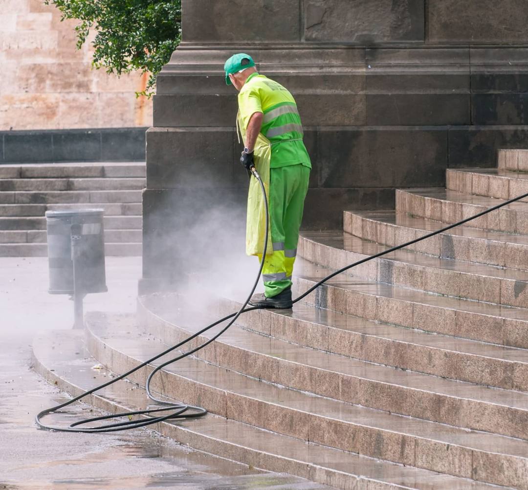 Worker pressure-washing stone steps